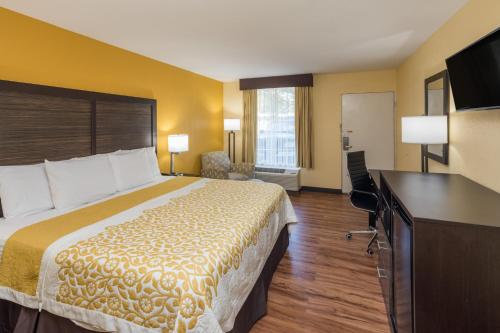 a hotel room with a bed and a flat screen tv at Days Inn by Wyndham Madison in Madison