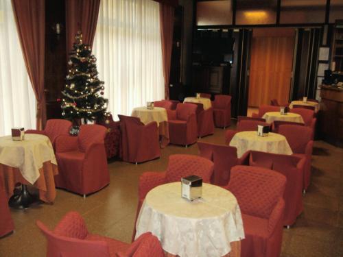 a room with tables and chairs and a christmas tree at hotel ristorante vittoria in Santhià