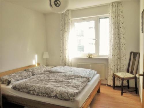 1 dormitorio con cama, ventana y silla en Große Wohnung für Gruppe en Núremberg