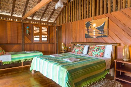 a bedroom with a bed in a room with wooden walls at Pousada Casa Suiça in Itarema