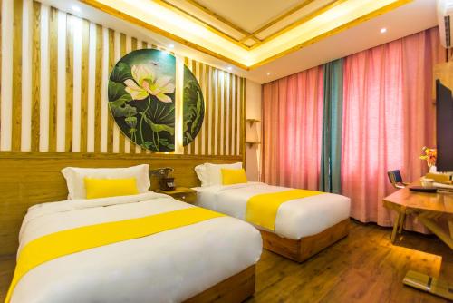 a hotel room with two beds and a table at Home of heart Inn in Zhangjiajie