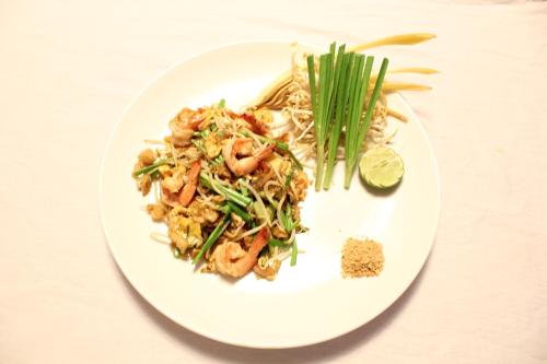 a plate of food with shrimp and noodles on a table at New York Hotel in Phnom Penh