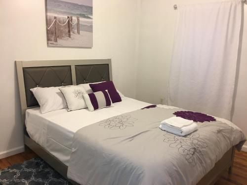una camera da letto con un letto con cuscini viola e bianchi di Mojoy Homesuites At Runyon a Newark