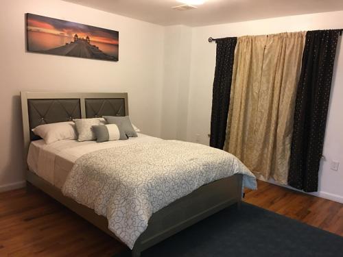 a bedroom with a bed and a picture on the wall at Mojoy Homesuites At Runyon in Newark