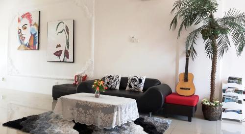a living room with a couch and a table and a guitar at Mahkota Cheras Sweet Condo 1-14 pax near MRT to KL in Kuala Lumpur