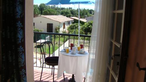 a table with food on a balcony with a view at Hôtel de la Poste Piscine in Peymeinade