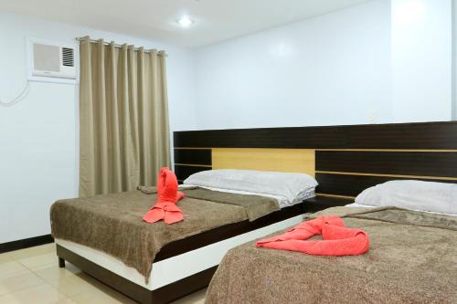 two beds in a hotel room with towels on them at Global 88 Apartelle in Cebu City