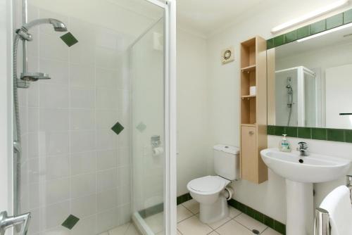 La salle de bains est pourvue d'une douche, de toilettes et d'un lavabo. dans l'établissement Villa Rosa at Palm Beach by Waiheke Unlimited, à Palm Beach