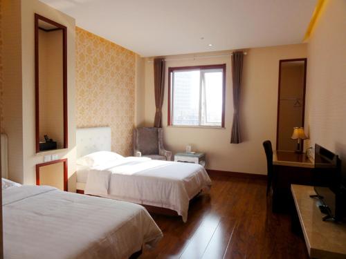 En eller flere senge i et værelse på Qingdao Hua Qi Kaiserdom Hotel