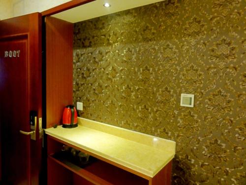a bathroom with a sink and a mirror on a wall at Hua Qi Kaiserdom Hotel Zhongshan Road St Michael's Cathedral and Zhanqiao Pier Qingdao in Qingdao