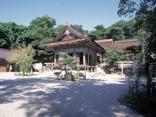 a building with a roof with a tree in front of it at Hotel Wellness Notoji in Hakui