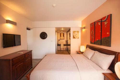 a bedroom with a white bed and a flat screen tv at Replay Condo One Bedroom in Bang Rak Beach