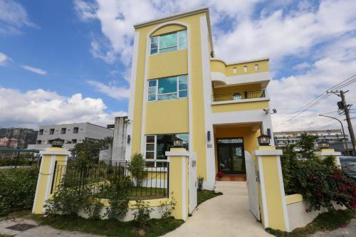 台东台东紫薇心民宿的黄色和白色的房子,带围栏