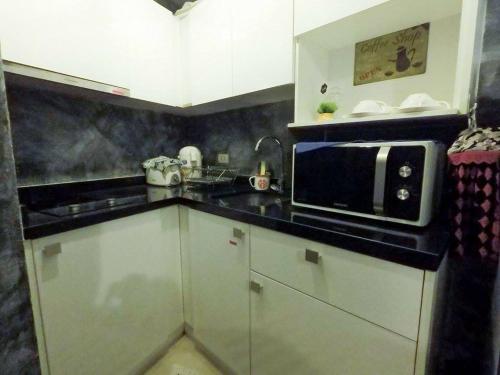 a kitchen with white cabinets and a microwave at Ban View Viman Condo in Hua Hin