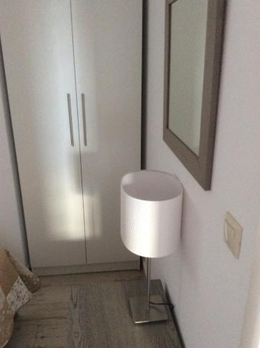 a white room with a lamp and a white cabinet at Marina in Nikiti