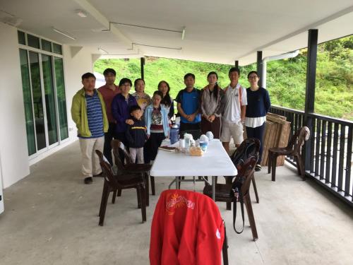 a group of people posing for a picture on a porch at Amazing Grace Lodge in Kundasang