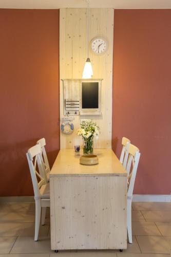 a dining room with a table with chairs and a clock at Villa-Meehr in Bantikow
