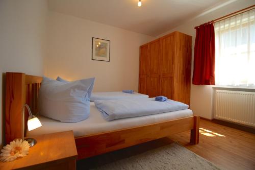 ガルミッシュ・パルテンキルヒェンにあるBergsonneのベッドルーム1室(白い枕とテーブル付)