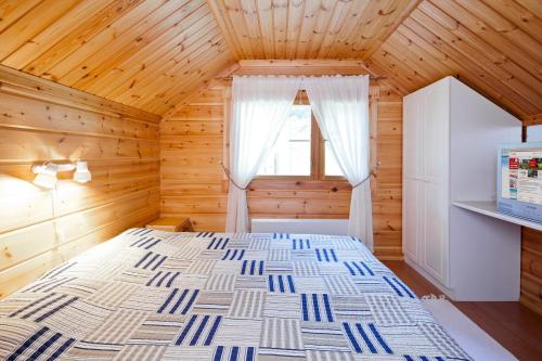 a bedroom with a large bed in a wooden room at Holiday Club Hannunkivi Cottages in Kivijärvi