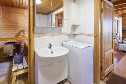 a bathroom with a sink and a washing machine at Holiday Club Hannunkivi Cottages in Kivijärvi