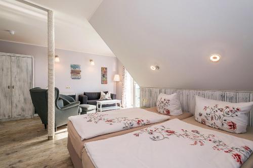 a bedroom with two beds and a living room at Villa-Meehr in Bantikow