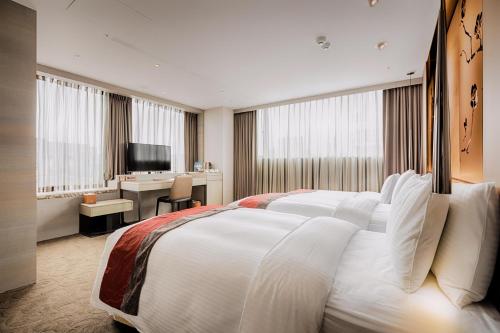 a hotel room with a large bed and a desk at Green World Grand NanJing in Taipei