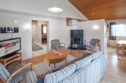 a living room with a couch and a fire place at Holiday Club Punkaharju Cottages in Kulennoinen