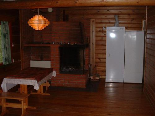 a living room with a brick fireplace and a refrigerator at Pitkäniemen Lomamökit in Joutsa