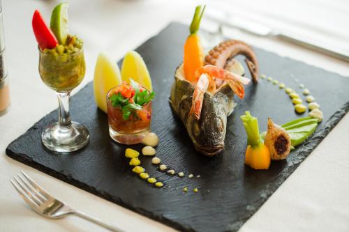 a plate of food with fish and vegetables on a table at Radisson Hotel Sfax in Sfax