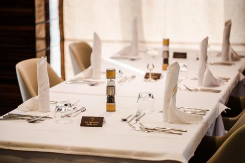a row of tables with white tablecloths and utensils at Radisson Hotel Sfax in Sfax