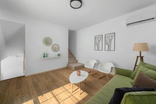 a living room with a green couch and a table at Milos Villas Complex in Pefki Rhodes