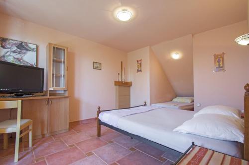 - une chambre avec un grand lit et une télévision dans l'établissement Apartments Oaza, à Dramalj