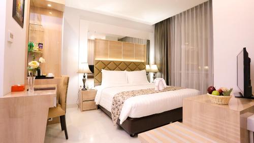a hotel room with a bed and a desk at Hotel Daily Inn in Jakarta