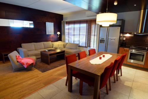 Holiday Club Tahko Spa Apartments في تاكوفوري: مطبخ وغرفة معيشة مع طاولة وأريكة