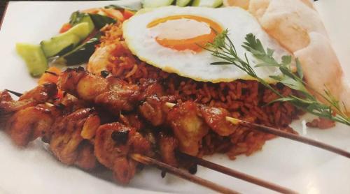 a plate of food with a fried egg and meat at Heaven Seven Kandy in Kandy