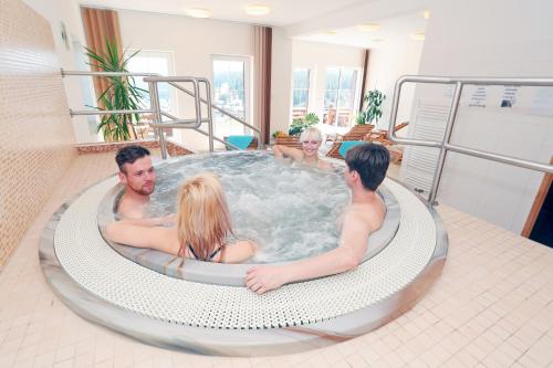 a group of people sitting in a hot tub at Aparthotel Teddy Kvilda in Kvilda