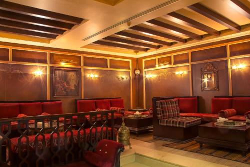 a room with red chairs and tables in a building at Thousand Nights Hotel Amman - فندق ثاوزند نايتس عمان in Amman