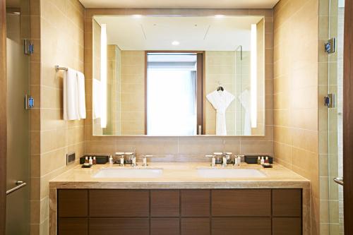 a bathroom with two sinks and a large mirror at LOTTE City Hotel Myeongdong in Seoul