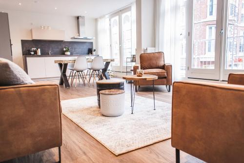 a living room with a table and chairs and a kitchen at Stadslogies in Leeuwarden in Leeuwarden