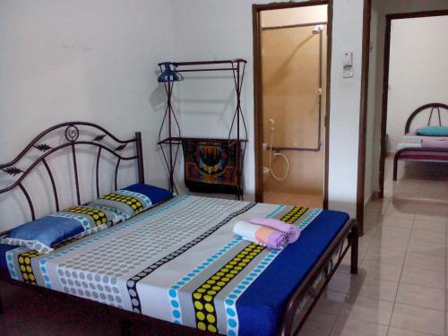Jati Indah Homestay في ميلاكا: غرفة نوم عليها سرير وفوط