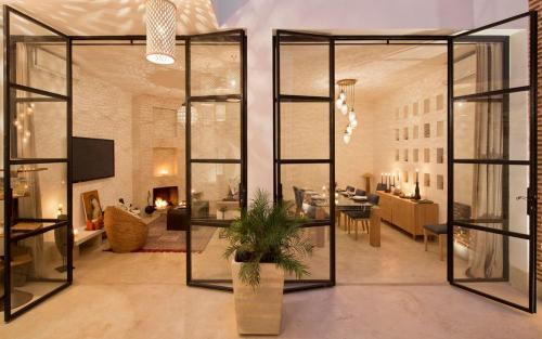 a living room with a large glass wall at Riad la Source du Desert in Marrakesh