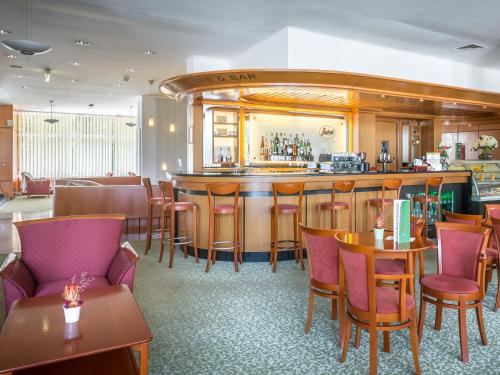a restaurant with a bar and tables and chairs at Ensana Sovata in Sovata