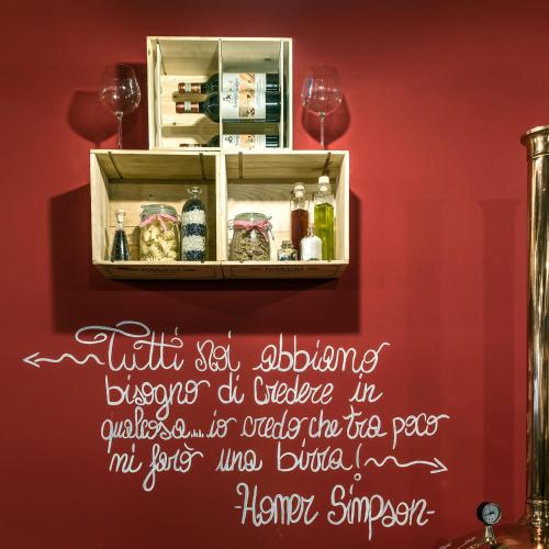 a sign on a red wall with a shelf with food at Hotel Blue Ribbon in Vercelli