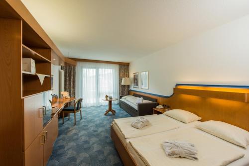 ローテンブルク・アン・デア・フルダにあるポストホテル ローテンブルクのベッドとデスクが備わるホテルルームです。