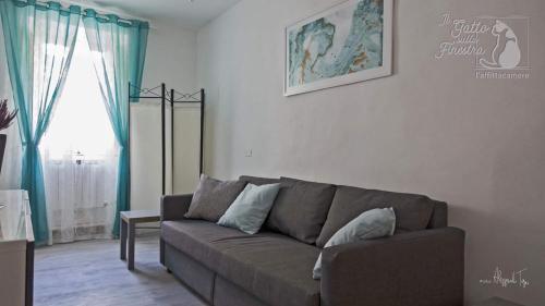a living room with a couch and a window at Il Gatto Sulla Finestra in Iesi