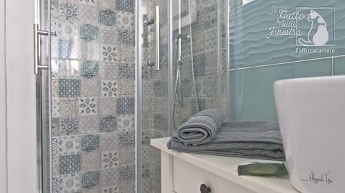 a bathroom with a shower and a sink with towels at Il Gatto Sulla Finestra in Iesi