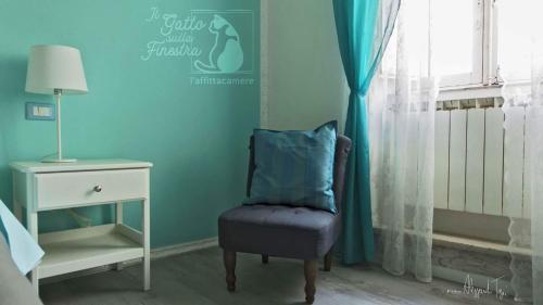 a blue room with a chair next to a window at Il Gatto Sulla Finestra in Iesi