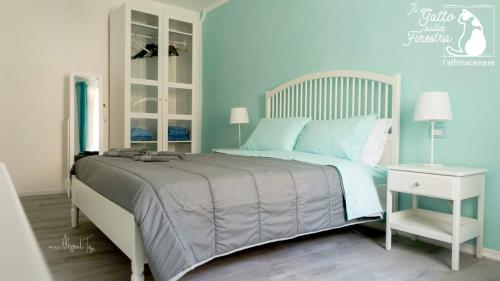 a bedroom with a large bed with blue walls at Il Gatto Sulla Finestra in Iesi