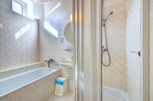 y baño con bañera, lavabo y aseo. en Hotel Pizzeria Istria, en Velké Losiny