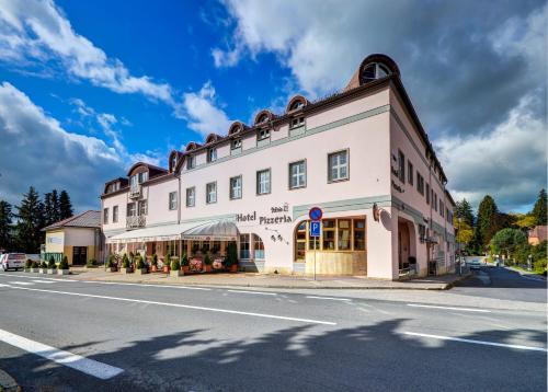 a large white building on the side of a street at Hotel Pizzeria Istria in Velké Losiny